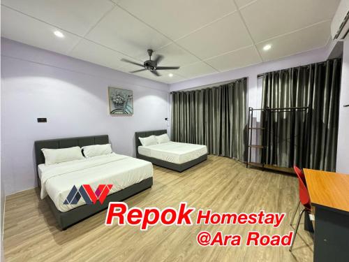 a bedroom with two beds and a ceiling fan at REPOK HOMESTAY in Sarikei