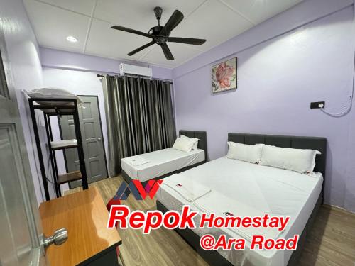 a room with two beds and a ceiling fan at REPOK HOMESTAY in Sarikei