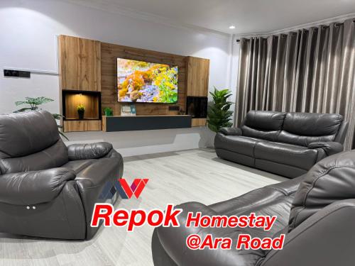 a living room with two couches and a tv at REPOK HOMESTAY in Sarikei