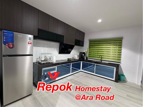 a kitchen with a stainless steel refrigerator and a sink at REPOK HOMESTAY in Sarikei
