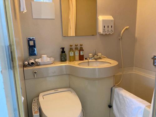 ein kleines Badezimmer mit Toilette und Waschbecken in der Unterkunft Hotel Castle Plaza Tagajo in Tagajo