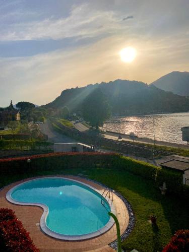 a swimming pool next to a body of water at OLIVIA LODGE in Sulzano