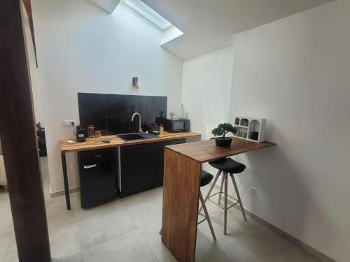 uma cozinha com um balcão e uma secretária com um lavatório em Appartement d'une chambre avec jacuzzi terrasse et wifi a Duppigheim em Duppigheim