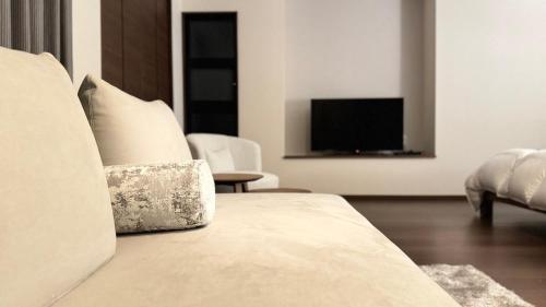 a living room with a bed and a television at Villa Hilala Miyakojima in Miyako Island