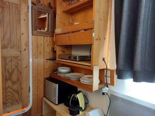 une cuisine avec un meuble avec des plaques et un micro-ondes dans l'établissement Résidence Nova - Studio pour 2 Personnes 11, à Arc 1800