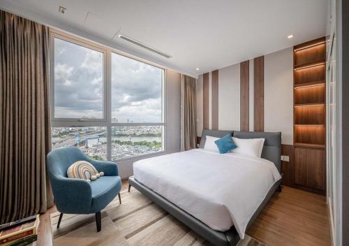 a bedroom with a bed and a chair and a window at Landmark 81 and Vinhomes Riverside Residence in Ho Chi Minh City