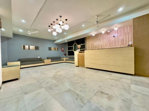 a lobby with a waiting room with couches and tables at Hotel Volga in Ahmedabad
