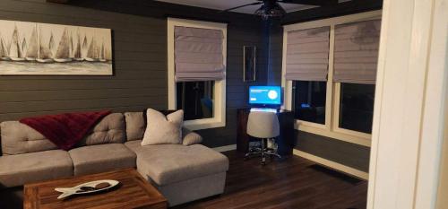 ein Wohnzimmer mit einem Sofa und einem TV in der Unterkunft Riverside Retreat in Benton Harbor