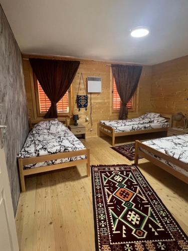 a room with three beds and a rug at Etno meandri Uvca in Sjenica
