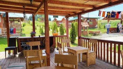 a patio with wooden tables and chairs on a deck at Etno meandri Uvca in Sjenica