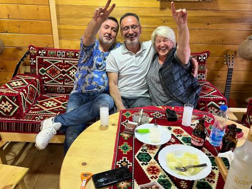 three people sitting on a couch with their hands in the air at Etno meandri Uvca in Sjenica