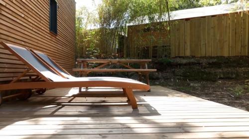 a patio with a bench and a picnic table at Lodging Le Lac in Lacanau