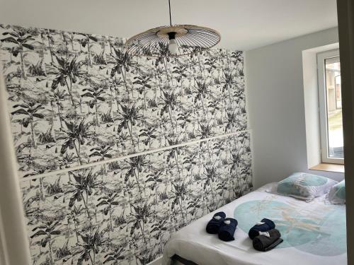 a bedroom with a black and white palm tree wallpaper at L exotique in Marlieux