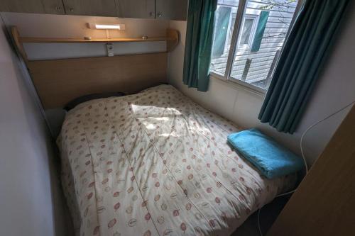 ein kleines Bett in einem kleinen Zimmer mit Fenster in der Unterkunft Charming cottage in La Tranche-sur-Mer in La Tranche-sur-Mer