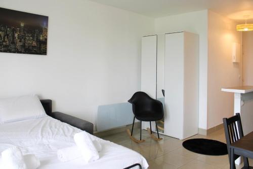 une chambre avec un lit, une chaise et une table dans l'établissement Cocoon of love at the gates of the City of Light, à Aubervilliers