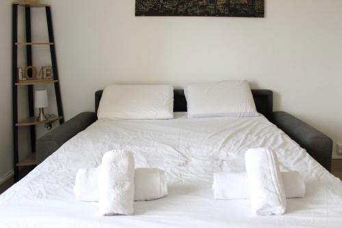 une chambre avec un lit blanc avec des oreillers blancs dans l'établissement Cocoon of love at the gates of the City of Light, à Aubervilliers
