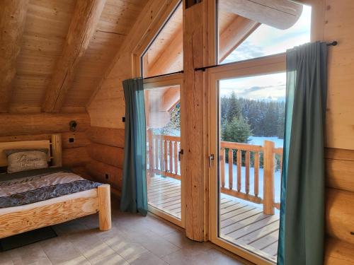 a bedroom with a bed and a large glass door at Böhmerwald Lodges in Ulrichsberg