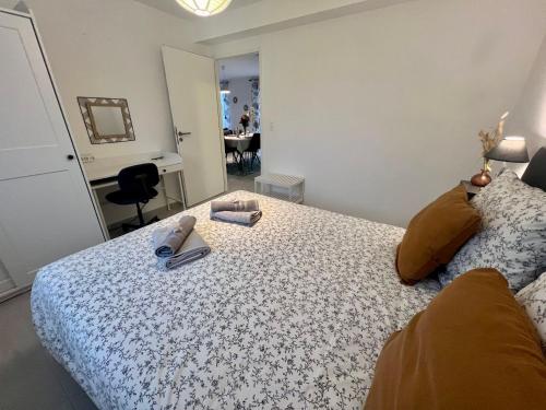 a bedroom with a bed with a book and a mirror at Le Belaven, Neuf, Cosy, Terrasse, jardin, Kerfany Plage, 1 à 6 pers in Moëlan-sur-Mer
