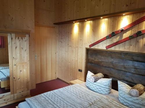 een slaapkamer met een bed en een houten muur bij Alpine Vacation Home in Schruns