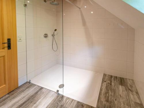 a shower with a glass door in a bathroom at Infanglalm "Attersee" in Neukirchen
