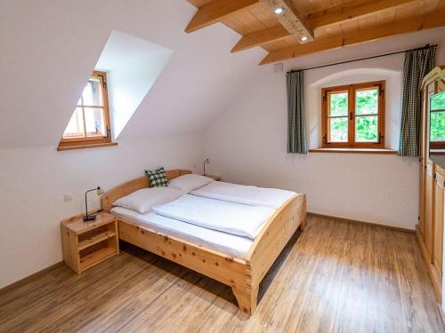 a bedroom with a wooden bed in a attic at Infanglalm "Attersee" in Neukirchen