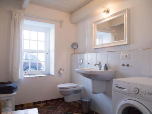 uma casa de banho com um lavatório, um WC e um espelho. em Old Bakery - Vorderhuus em Hinte