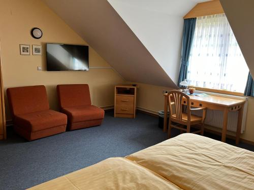 een slaapkamer met een bed, een bureau en een stoel bij Mini Hotel in Škofja Loka