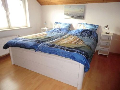 um quarto com uma cama grande e um edredão azul em Lütje Carolinensiel Harlesiel em Carolinensiel