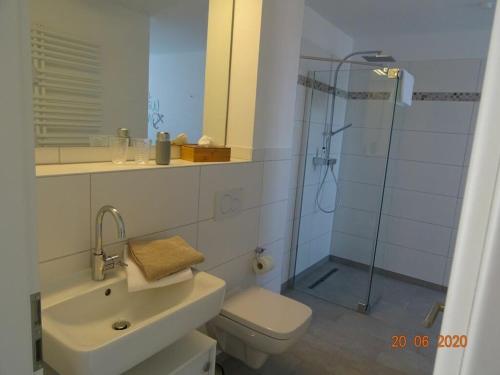 a bathroom with a shower and a toilet and a sink at Old Printing House Holiday Apartment Bodoni in Norderney