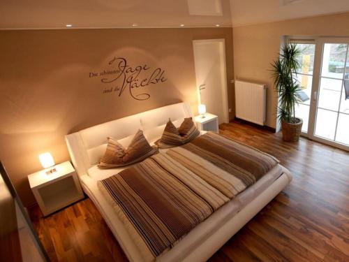 ein Schlafzimmer mit einem großen Bett mit einem Schild an der Wand in der Unterkunft Holiday home ALEA-VITA 