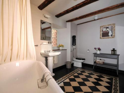 a bathroom with a tub and a sink and a toilet at Le Prévôt Comfortable holiday residence in Hunawihr