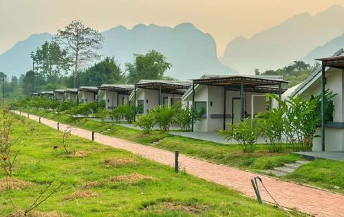 una fila de casas con montañas en el fondo en Family Land Camping Resort en Vang Vieng