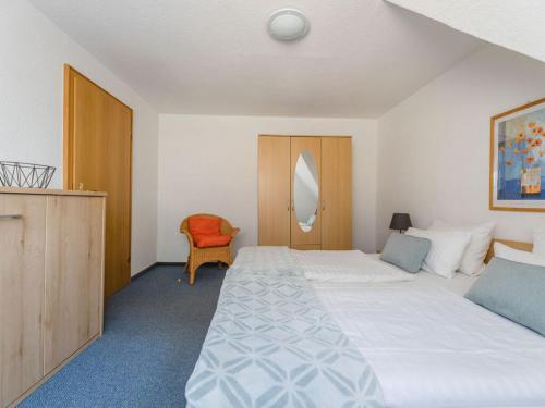 una habitación de hotel con 2 camas y una silla en House on the sunny slope type C en Eslohe