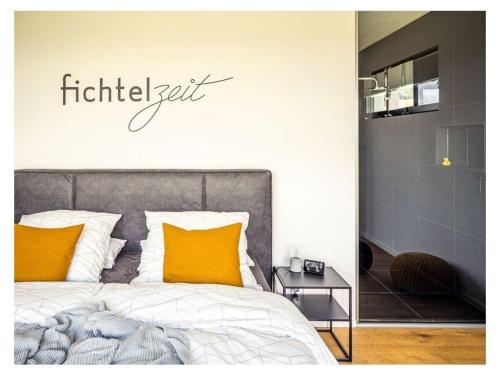 um quarto com uma cama com uma placa na parede em FichtelTijd Wellness Sauna Whirlpool em Waldershof