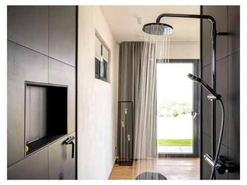 uma casa de banho com um chuveiro, uma televisão e um chuveiro em FichtelTijd Wellness Sauna Whirlpool em Waldershof