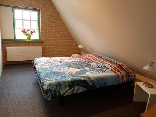 een slaapkamer met een bed en een raam bij Landelijk leven in 't Zand