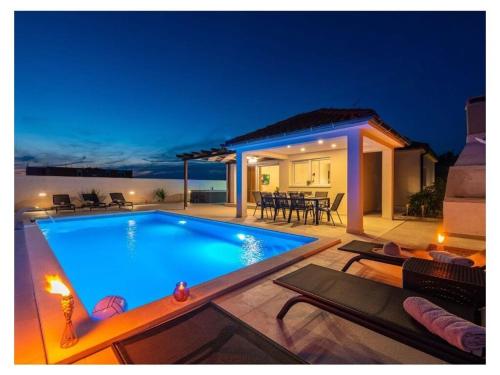 a swimming pool in front of a house at night at Villa Sabun Luxury Villa with Poo, Jacuzzi in Privlaka