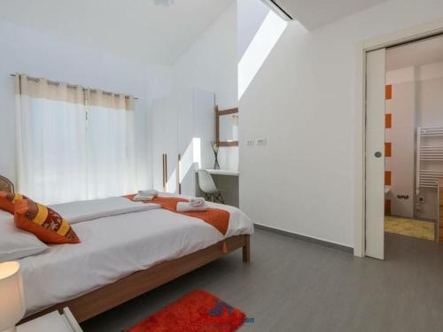 een witte slaapkamer met 2 bedden en een badkamer bij Elsa Comfortable holiday residence in Krnica