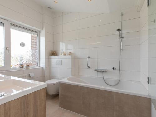 尼維萊特的住宿－Spacious holiday home with garden，白色的浴室设有浴缸和卫生间。