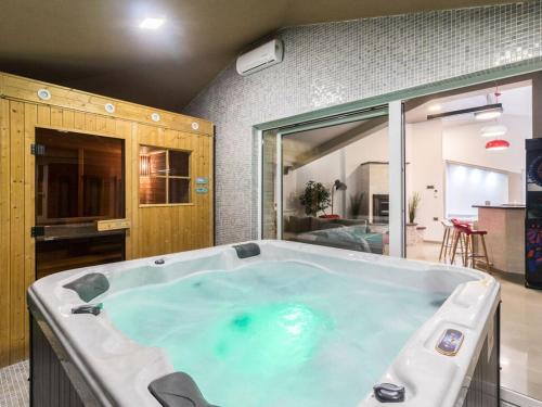 a large hot tub in a room with a kitchen at Istra Kamen Comfortable holiday residence in Valtura