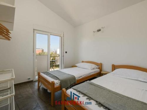 twee bedden in een kamer met een raam bij Tiffany Comfortable holiday residence in Fažana