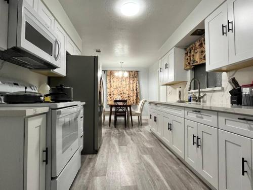 a kitchen with white cabinets and a black refrigerator at 3Beds Full Kitchen with On Site Parking Close to UC Davis Medical Center in Sacramento