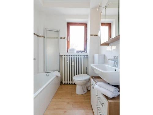 La salle de bains blanche est pourvue de toilettes et d'un lavabo. dans l'établissement Country House Mettenberg, à Eslohe