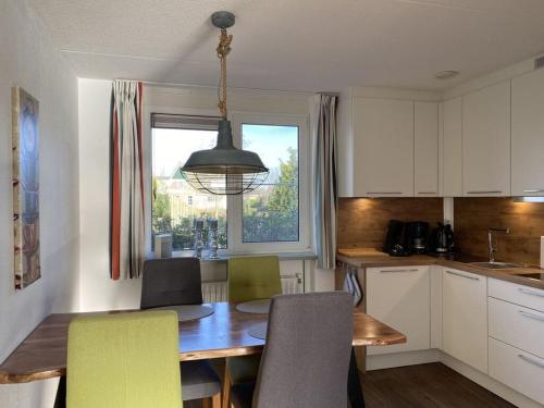 a kitchen with a table and chairs and a window at Villa Zeezicht Modern retreat in Makkum