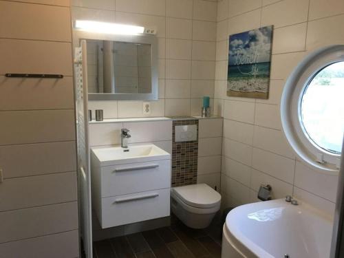 y baño con lavabo, aseo y espejo. en Villa Zeezicht Modern retreat, en Makkum