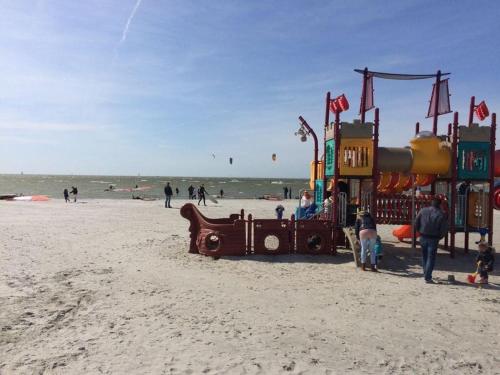 a group of people on a playground on the beach at Villa Zeezicht Modern retreat in Makkum