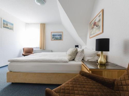 um quarto de hotel com uma cama e uma cadeira em Sunny slope type G em Eslohe