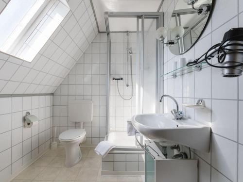 a white bathroom with a sink and a toilet at Dreamy apartment near forest in Eslohe