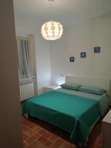 a bedroom with a green bed and a chandelier at Il porto di Iskra in Vasto
