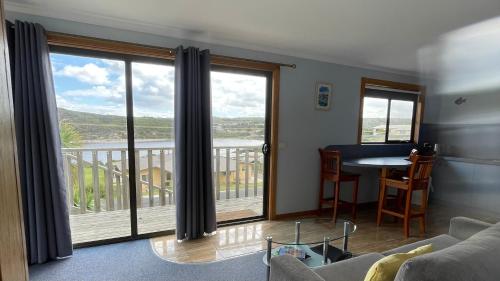 a living room with a view of a balcony at Sunset Holiday Villas in Arthur River